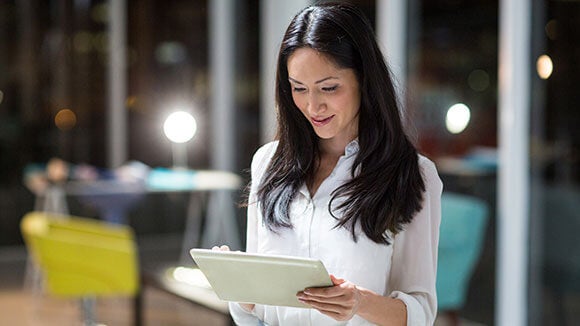 Woman on her tablet Woman looking at her LinkedIn profile on her tablet