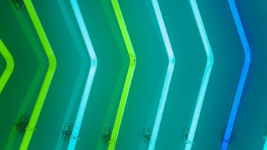 Columns of neon lights in different shades of blue and green representing arrows
