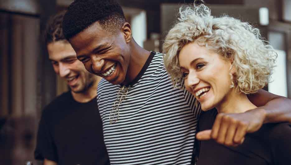 Diverse group of friends walking in the city. Cheerful young men and woman hangout out outdoors.