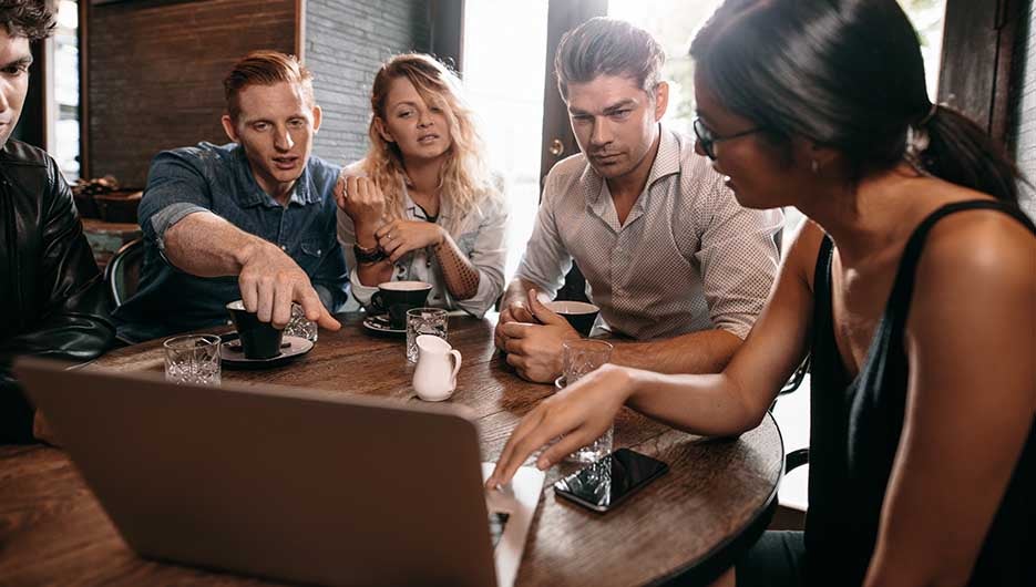 BE-21b-group looking at laptop-935x530